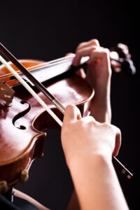 Woman with the violin over black background. Image by Racool_studio on Freepik